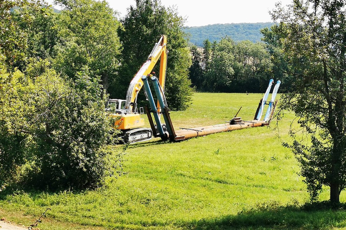 Excavadora tendiendo una tubería de acueducto en el campo